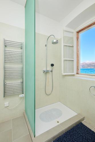 a bathroom with a shower with a glass door at La Villa Lopud- Breakfast & Dinner Included in Lopud