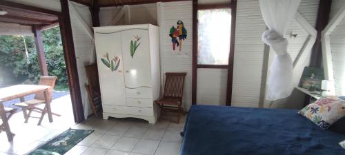 a bedroom with a bed and a dresser in a room at bungalow tout confort avec piscine partagee à 5 mn de la mer in Saint-François