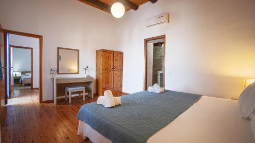 a bedroom with a bed and a desk and a mirror at Villa Niki in Loutro