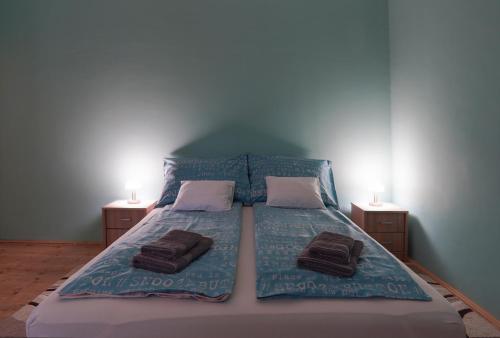 a bedroom with a bed with two towels on it at Dia Apartman Pécs in Pécs