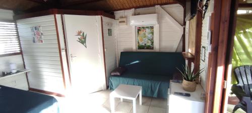 a small room with a couch and a table at bungalow tout confort avec piscine partagee à 5 mn de la mer in Saint-François
