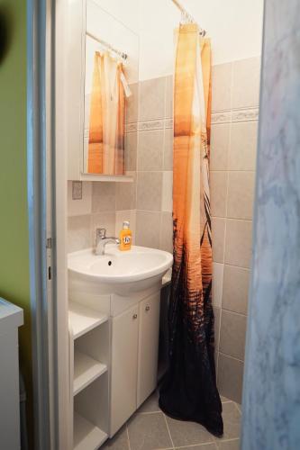 a bathroom with a sink and a shower curtain at Dia Apartman Pécs in Pécs