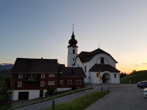 eine Kirche mit einem Uhrturm und einem Gebäude in der Unterkunft Gasthaus Bären Schlatt in Appenzell