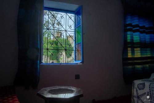 a stained glass window in a room with a table at CASA TROUSSI in Chefchaouen