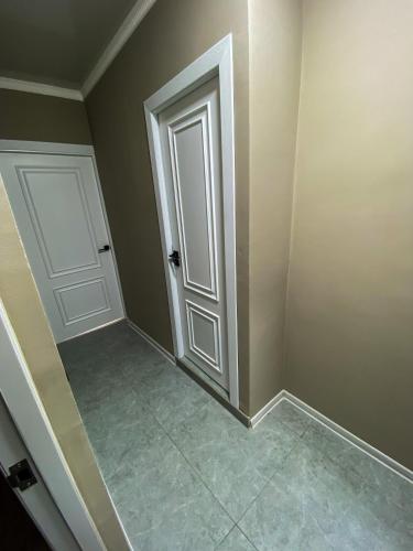 una stanza vuota con una porta e un pavimento piastrellato di Квартира в центре города a Nukus