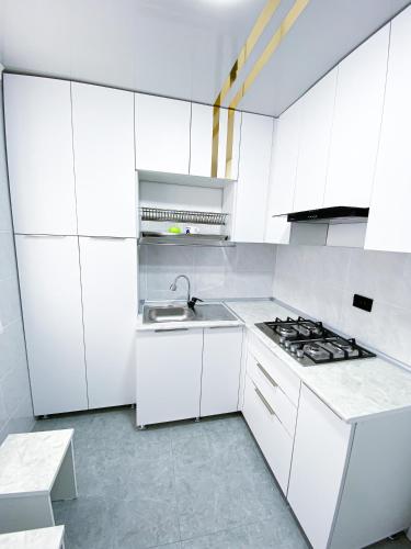 una cucina bianca con lavandino e piano cottura di Квартира в центре города a Nukus