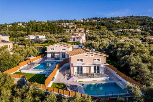 una vista aérea de una casa con 2 piscinas en Elianthos Luxury Villas, en Tsoukaladhes