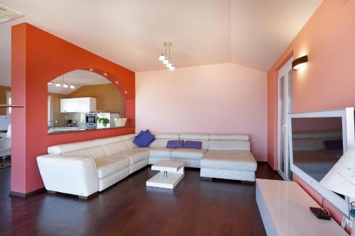a living room with a white couch and orange walls at Vila Elena in Vrbnik