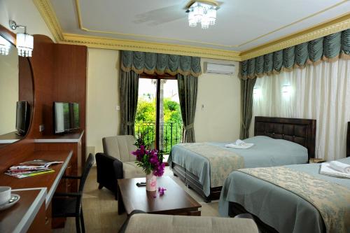 a hotel room with two beds and a desk at Riverside Garden Resort in Kyrenia
