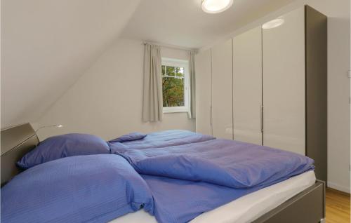 KutzowにあるReetdachhaus 8 Auf Usedomのベッドルーム1室(青いシーツと窓付)