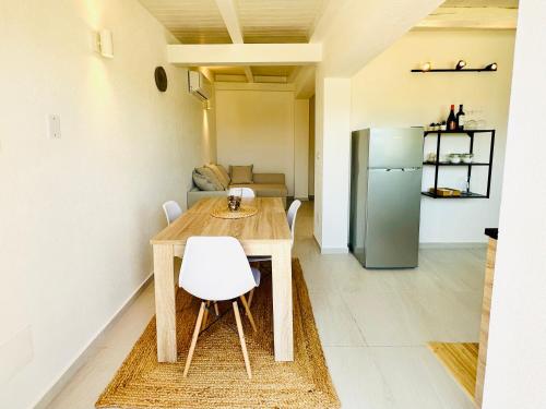 a kitchen with a wooden table and a refrigerator at Plemmirio Apartments in Siracusa