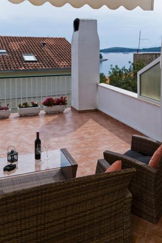 a patio with a table with a bottle of wine at Guesthouse Aurora in Hvar