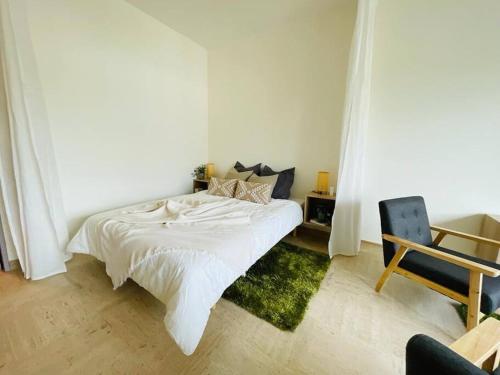 sypialnia z białym łóżkiem i krzesłem w obiekcie Spacious 1 bed in the Heart of City Center - 21 w Luksemburgu