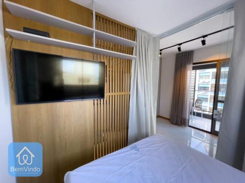 a bedroom with a flat screen tv on a wall at Apartamento com linda vista mar no Smart Barra 2 in Salvador