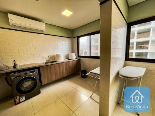 a laundry room with a washing machine and a sink at Apartamento com linda vista mar no Smart Barra 2 in Salvador