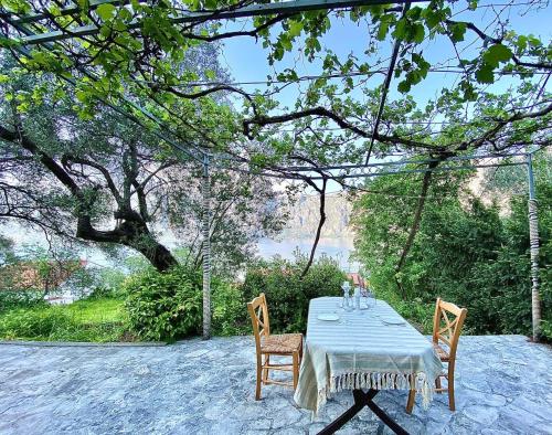a table with two chairs and a blue tablecloth on it at Sea view country house in Prčanj