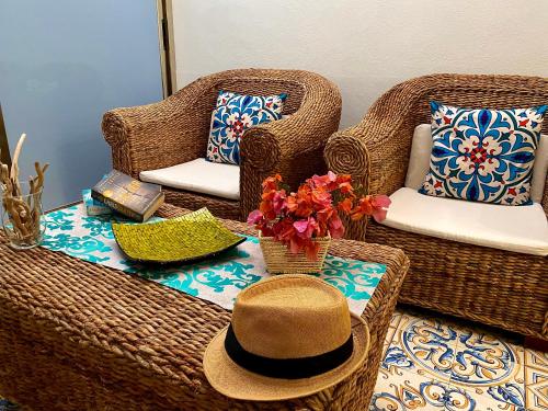 a hat sitting on a table with wicker chairs at Alpha22 Apartment in Giardini Naxos