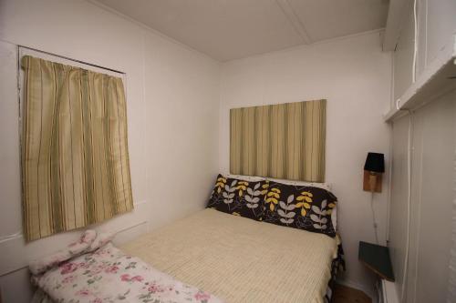 a small bedroom with a bed and a window at 1 Bdrm Country cottage #5 - Rosewood Cottages in Southampton