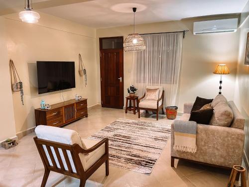 a living room with a couch and a tv at Comfort Oasis in Dar es Salaam
