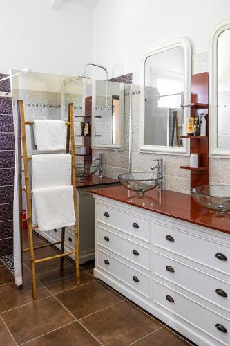a bathroom with two sinks and two mirrors at Les gites du plateau de gissac in Sainte-Anne