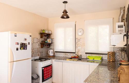 eine Küche mit weißen Geräten und einem weißen Kühlschrank in der Unterkunft Bella Vista Casa con pileta y terraza in Villa Carlos Paz