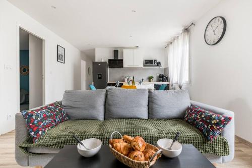 un salon avec un canapé et une table avec une corbeille de pain dans l'établissement Le Grand Bellevue Hypercentre 3 chambres face à la Gare SNCF, à Saint-Étienne
