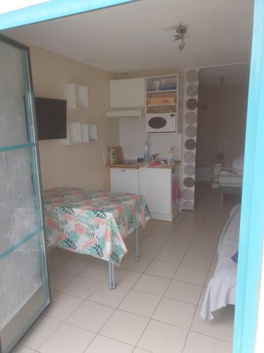 Cette chambre comprend un lit, une table et une cuisine. dans l'établissement Studio cabine à 200m de la plage sainte Cécile, à Camiers