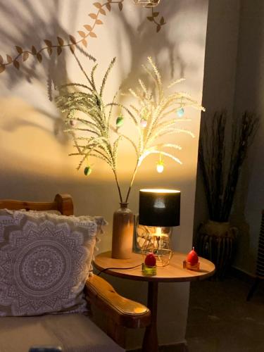 イドラにあるGuesthouse Coraliのリビングルーム(花瓶とランプ付きのテーブル付)