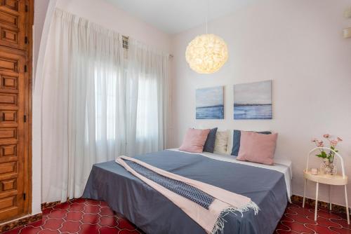 sypialnia z łóżkiem z niebieską pościelą i różowymi poduszkami w obiekcie Beautiful house with sea views and private pool w mieście Torrevieja