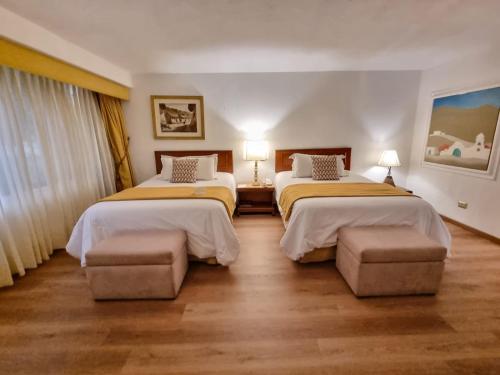 a hotel room with two beds and two chairs at Antara Hotel & Suites - Miraflores in Lima