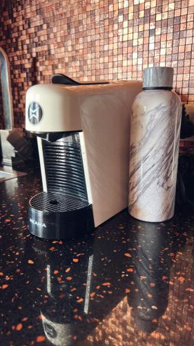 a kitchen counter with a juicer and a bottle on it at Luxury Dreamland Oasis Apartments in Chakvi