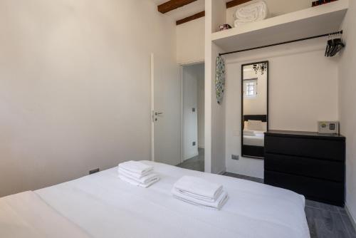 - une chambre avec un lit blanc et des serviettes dans l'établissement Rialto Boutique Apartment, à Venise