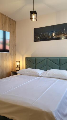 a large white bed in a bedroom with a city at Apartament Sienkiewicza 22 in Zamość