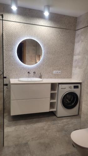 a bathroom with a sink and a washing machine at Apartament Sienkiewicza 22 in Zamość