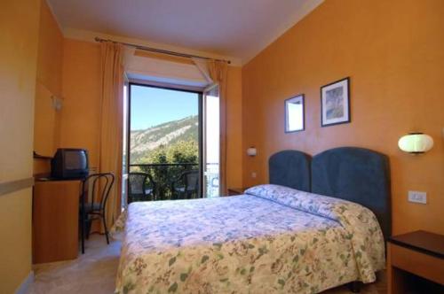 a bedroom with a bed and a large window at Hotel Ede in Caramanico Terme
