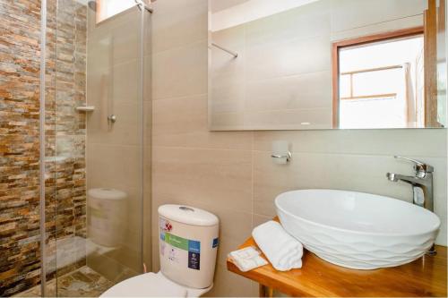 a bathroom with a sink and a toilet and a shower at Arca Tayrona Restaurant & Hostal in Santa Marta