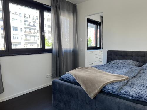 Luxury Waterfront Apartment في برلين: غرفة نوم بسرير ونوافذ