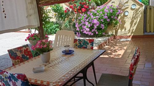 una mesa y sillas con flores en el patio en Casa in giardino, en Piombino