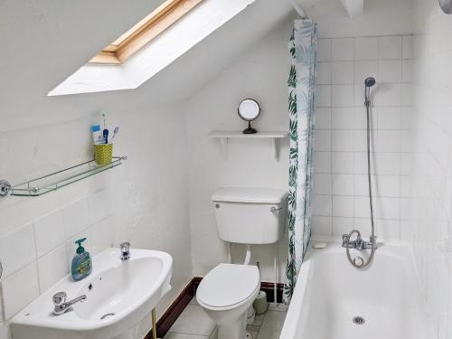 a white bathroom with a toilet and a sink at Market Place in Workington