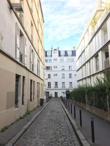 an empty street in a city with buildings at Joli Studio Parisien in Paris