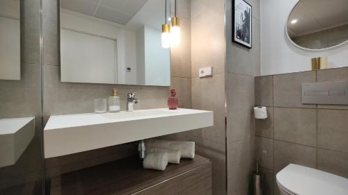a bathroom with a white sink and a toilet at ALLONBAY sun & beach penthouse in Villajoyosa
