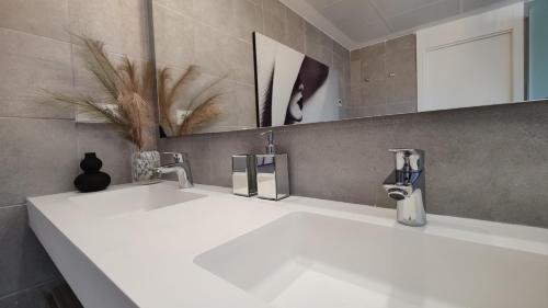 a bathroom with two sinks and a mirror at ALLONBAY sun & beach penthouse in Villajoyosa