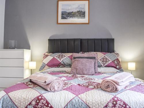 um quarto com uma cama com almofadas rosas e roxas em Woodside Retreat, Number 37 em Worthington
