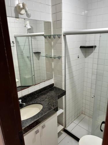a bathroom with a sink and a shower with a mirror at Monte Castelo Flat 08B in Sairé