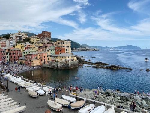 a group of buildings and a beach with boats at Waterfront District Apartment in Genova