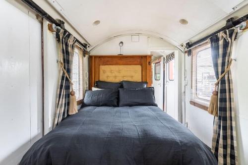 a bed in the back of an rv at Tiny House Train-Eco stay in Upper Hutt