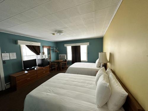 a hotel room with two beds and a television at The Colonial Inn & Creamery in Watkins Glen
