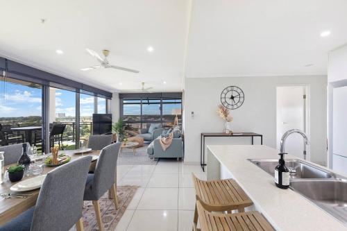 a kitchen and dining room with a view of a living room at 'Opal of Darwin' Breezy Living Atop Blue Horizons in Darwin