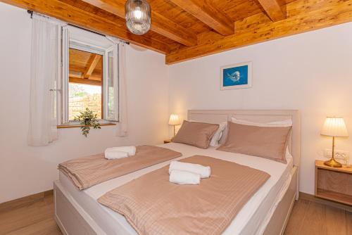 a bedroom with a large bed with two pillows at Holiday Home Parona in Šibenik