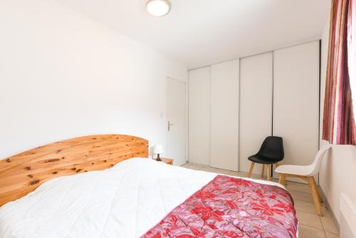 a bedroom with a large bed and a chair at La Tour de Guet in Montbrun-les-Bains